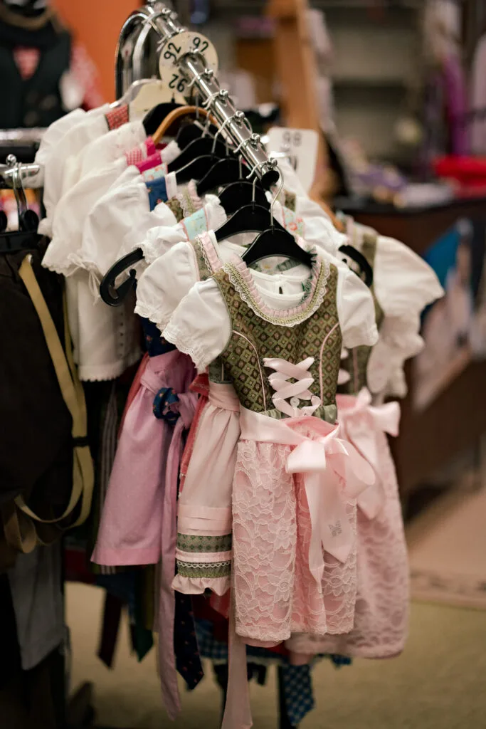 Kinderdirndl in Rosa und Grün auf einem Kleiderständer im Laden
